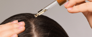 girl applying oil on scalp